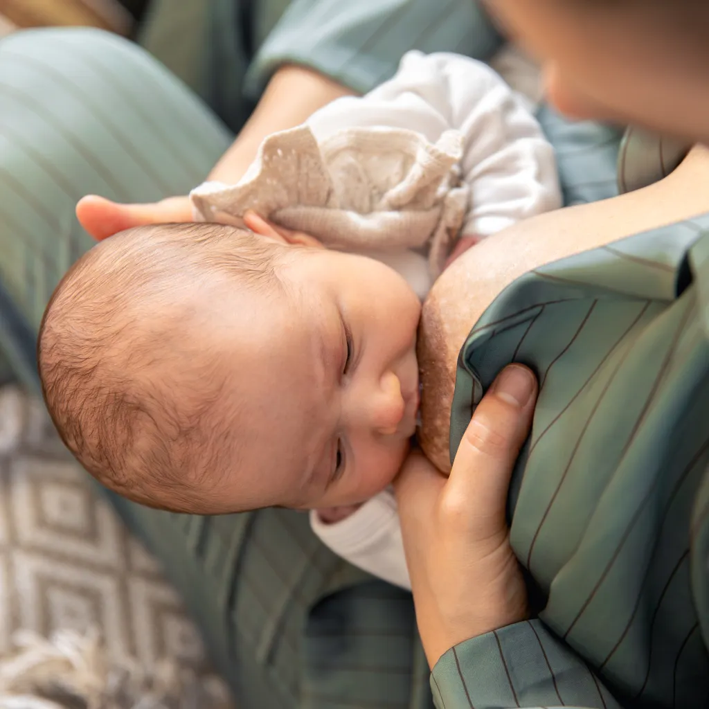 Mamma che allatta il neonato al seno, produzione di latte materno.