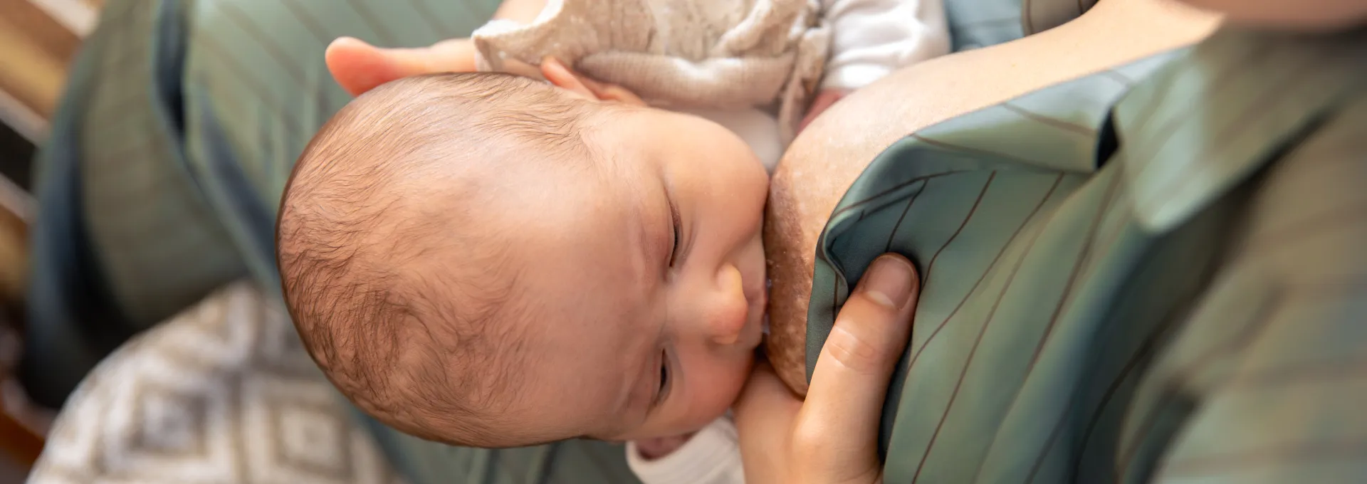 Mamma che allatta il neonato al seno, produzione di latte materno.